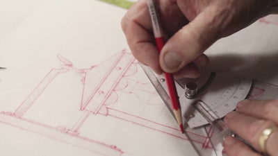 video of red hand sketches into video of fabricating light fixtures including welding and painting